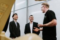 three men talking in a factory