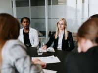 women at a table having a conference