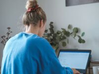 A woman sitting at her desk in and studies for her master program