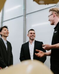 three men talking in a factory