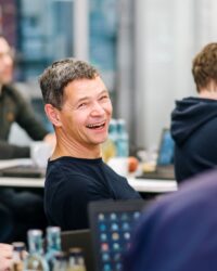 group sitting at a table - one man is laughing